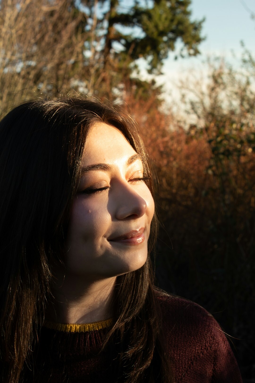 Close portrait of a young girl laughing outdoors in soft light